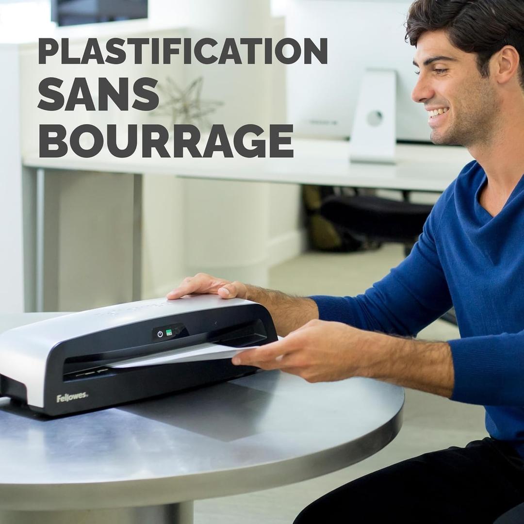Plastifieuse à pochettes NEPTUNE 3 FELLOWES — Utilisateur engageant une pochette dans la fente, machine posée sur une table ronde