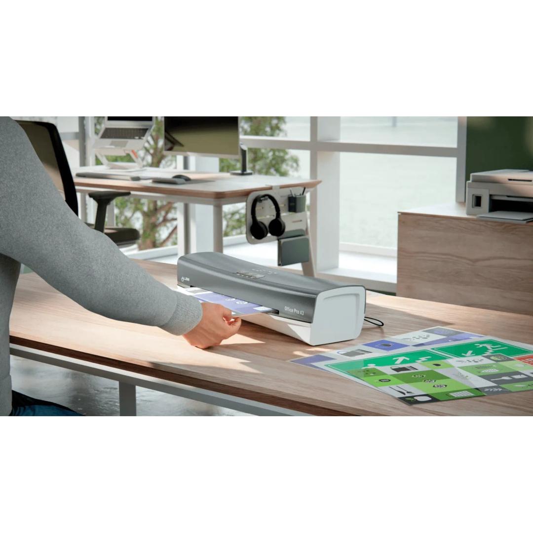 Plastifieuse à pochettes iLAM Office Pro A3 LEITZ - La plastifieuse à pochettes Leitz iLAM Office Pro A3 posée sur un bureau, un document engagé dans la fente