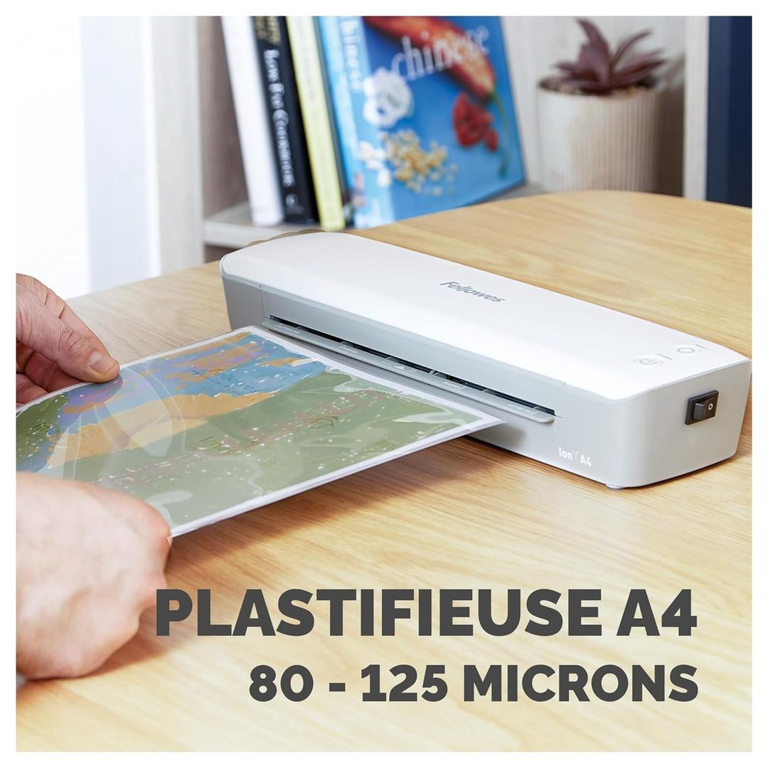 Plastifieuse à pochettes ION A4 FELLOWES — Main insérant une pochette dans la fente, machine posée sur un bureau